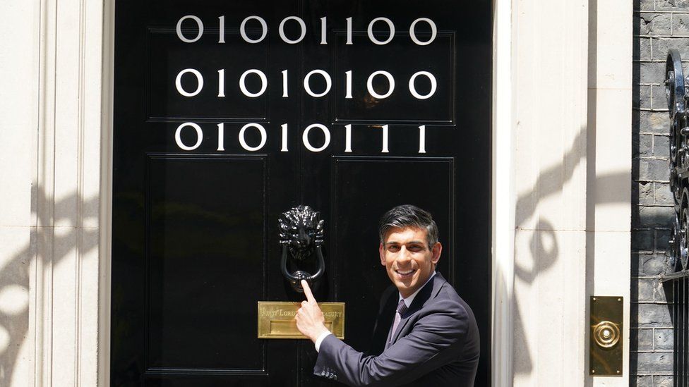 Prime Minister Rishi Sunak at the door of Number 10 Downing Street decorated with binary code to mark London Tech week in June