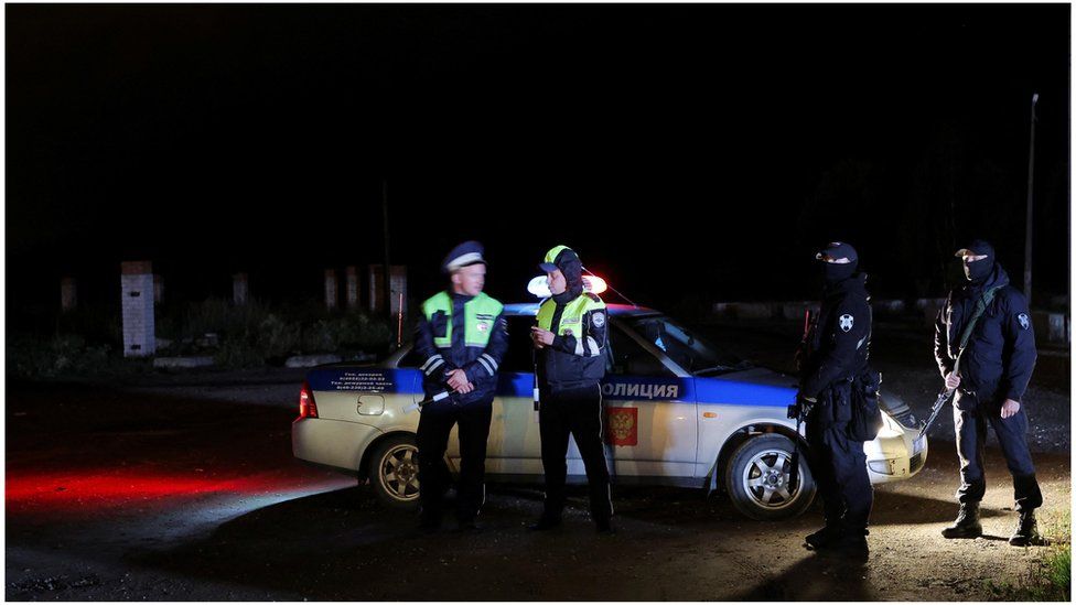 Police stand guard at a checkpoint on a road near the accident scene following the crash of a private jet linked to Wagner mercenary chief Yevgeny Prigozhin