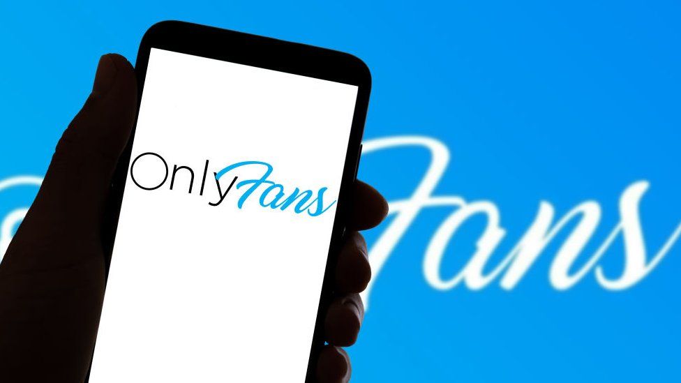 OnlyFans logo on smartphone in front blue background with logo.