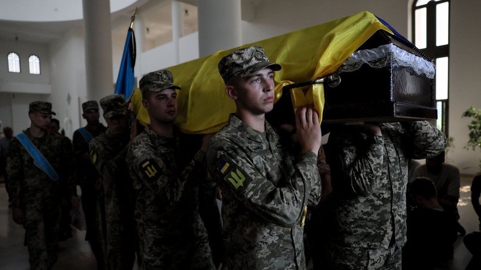 The pilot's coffin - draped in Ukraine's blue and yellow national flag - was carried by honour guard servicemen