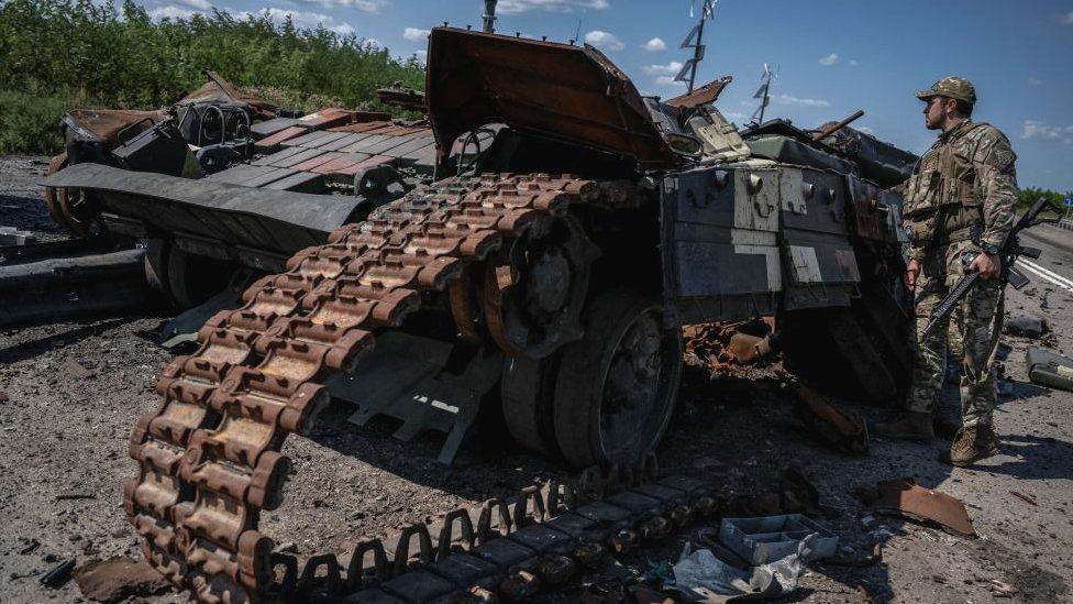 A Ukrainian serviceman looks at a destroyed Ukrainian tank near the village of Robotyne