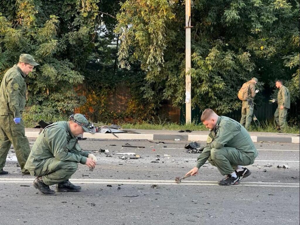Российские власти осматривают место происшествия после взрыва автомобиля, в результате которого погибла Дугина в 2022 году