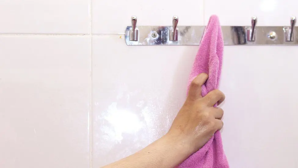 Стандартное изображение женщины, тянущейся за полотенцем