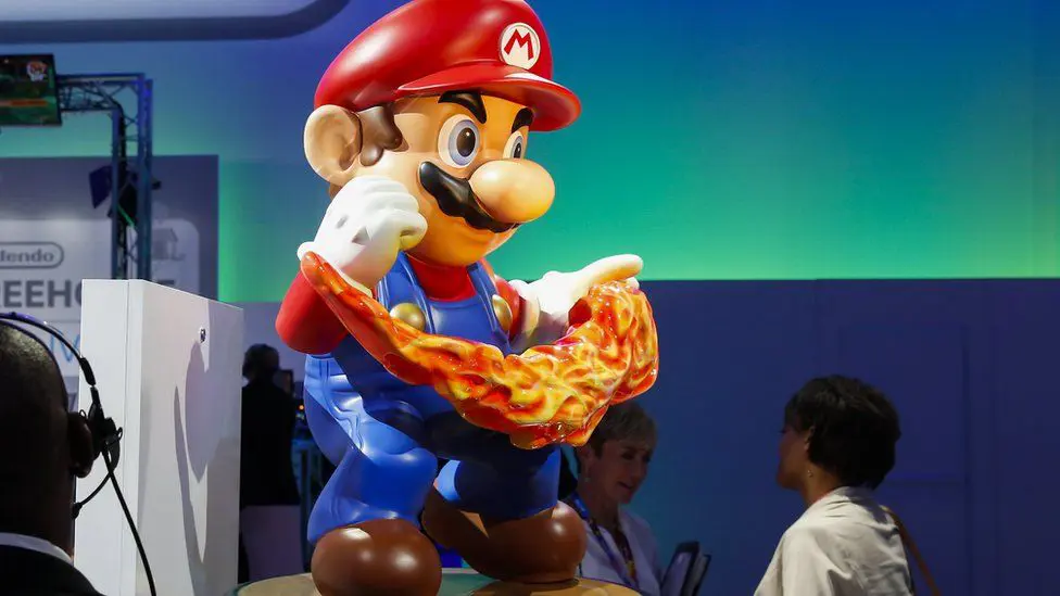 Статуя Супер Марио, на которую кто-то смотрит, на выставке E3