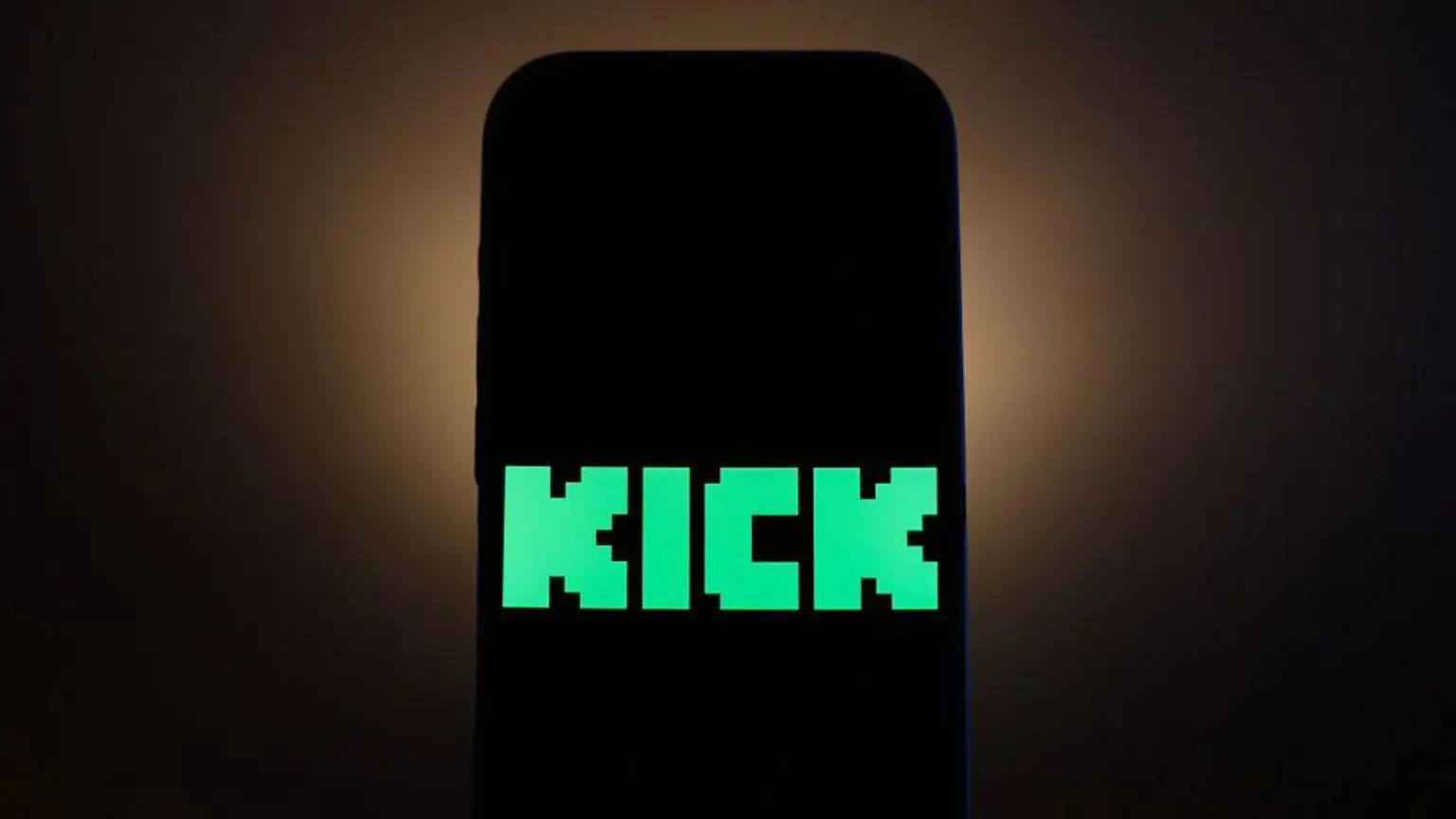 Французское правительство требует объяснений по поводу смерти стримера 1 Ярко-зелёный логотип Kick в пиксельной стилистике отображается на чёрном экране смартфона.
