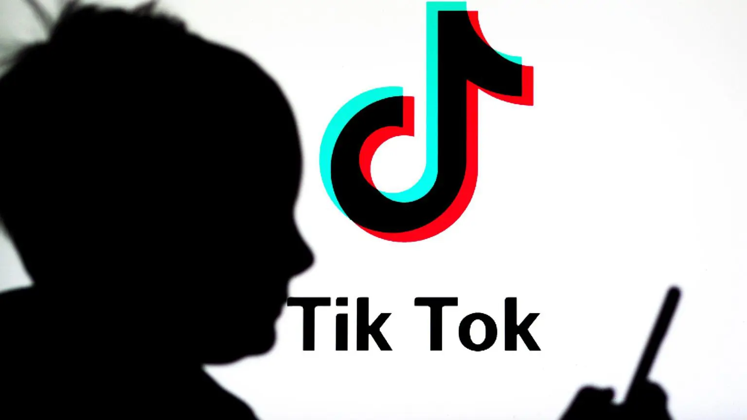 Защита данных детей в TikTok недостаточна, заявляют канадские специалисты по защите конфиденциальности 1 Силуэт ребёнка, смотрящего на смартфон, на фоне логотипа TikTok на белом фоне.