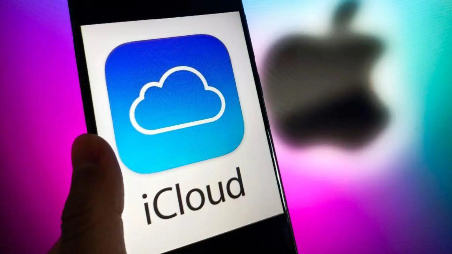 Миллионы пользователей iCloud могут претендовать на долю в размере 3 миллиардов фунтов стерлингов после того, как дело Apple получило одобрение в Великобритании. 1 На белом фоне изображен телефон с надписью iCloud черными буквами и сине-белым логотипом iCloud в виде облака. За ним на фиолетовом фоне расположен размытый черный логотип Apple.